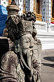 Bangkok Wat Arun - Detail of the precint of the sacred area of the ubosot with chinese noble man sitting on chair. 